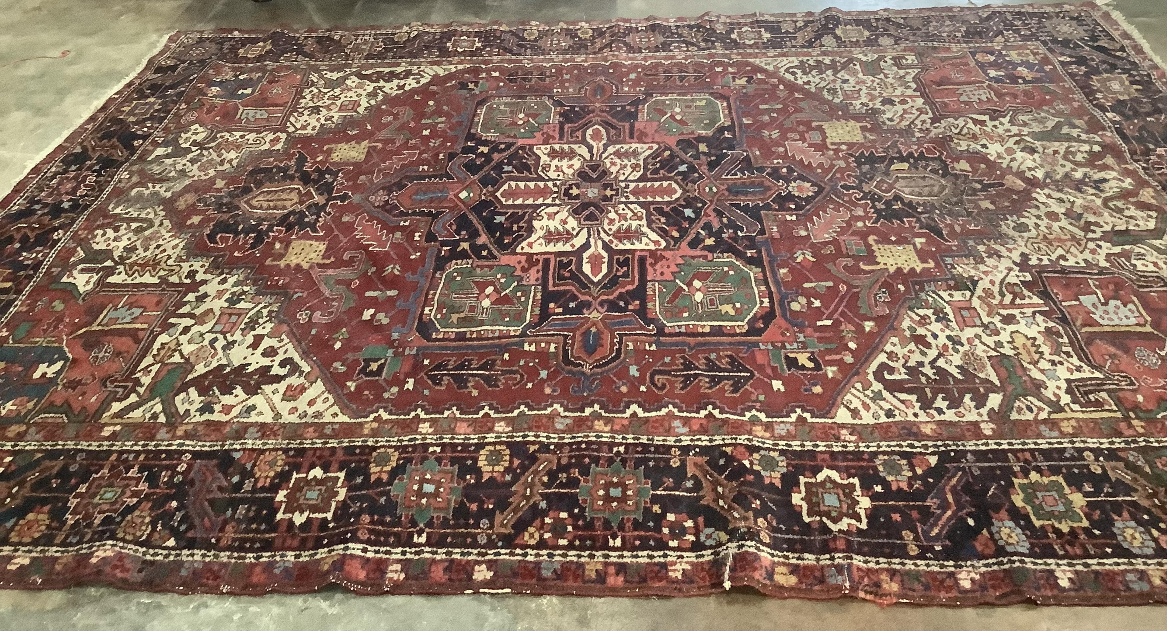 A Heriz red ground carpet, 340 x 267cm. Condition - poor to fair